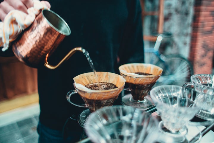 Person pouring hot water into pour over coffee kettle