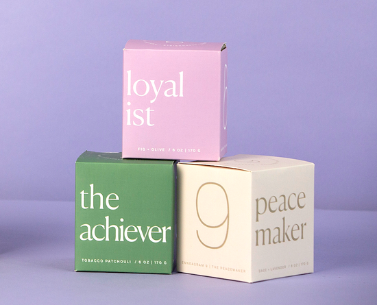 Three candle packaging from Enneagram stacked on top of each other.