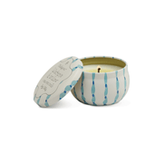 The Wisteria & Willow - Tulip 2 oz Tin Candle comes in a round, white tin with blue wavy stripes and a matching lid. The unlit candle offers a spring-inspired scent, with the lid placed beside the decorative container.