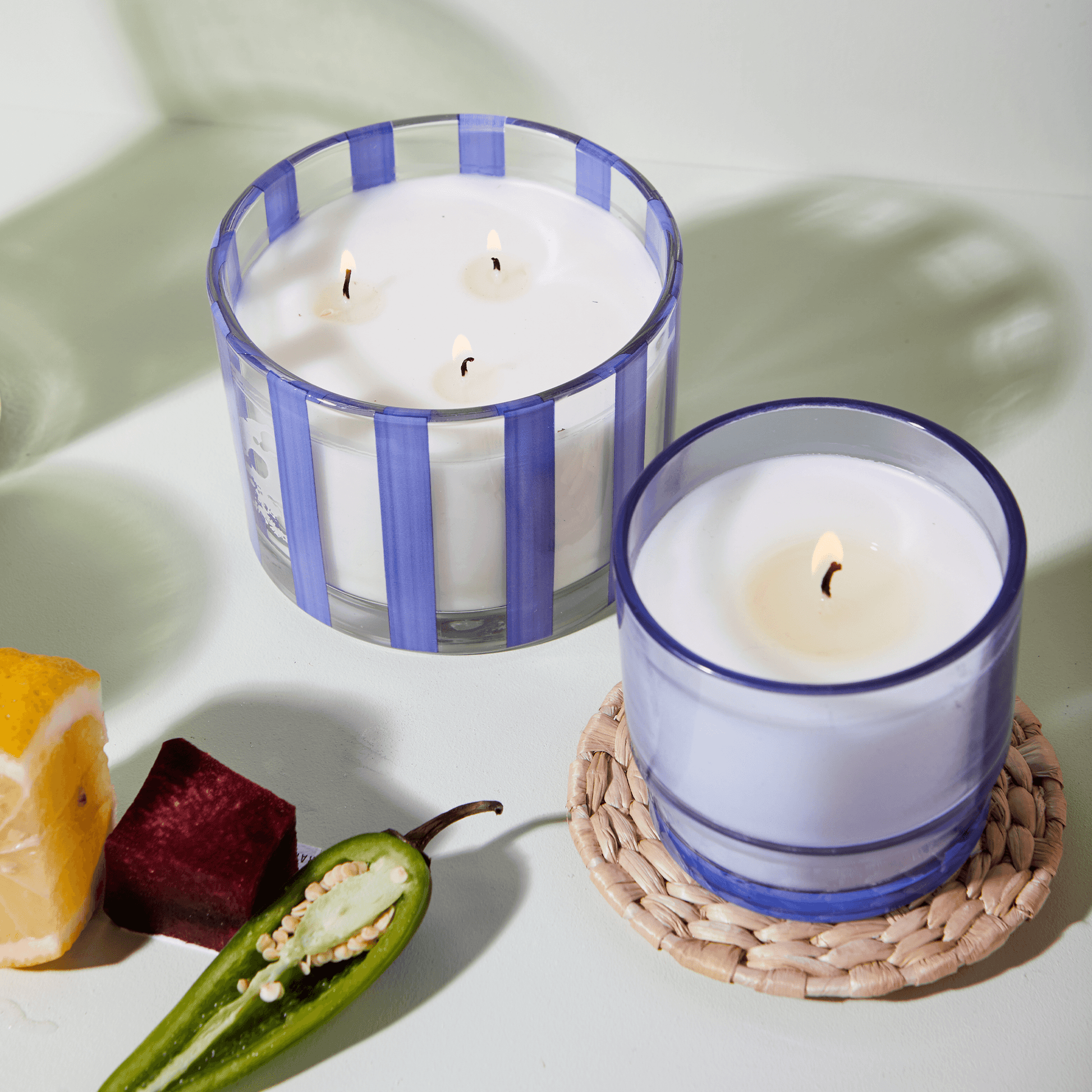 7 oz Al Fresco candle with a blue-tinted glass vessel pictured next to the larger 12oz Al Fresco candle of the same color.