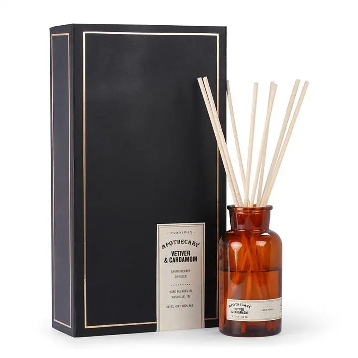 Brown glass apothecary bottle filled with diffuser sticks; pictured next to the black packaging