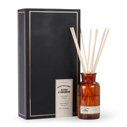Brown glass apothecary bottle filled with diffuser sticks; pictured next to the black packaging
