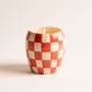 11 oz ceramic vessel with rounded cylindrical shape and a red and white checker design; one cotton wick