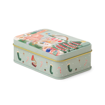 5 oz holiday tin with custom artwork; lid shows a living space decorated for the Holidays; sides of the tin have stockings and candy canes