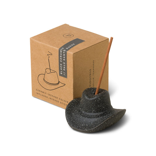 black ceramic cowboy hat holding incense stick in the top; pictured in front of brown packaging