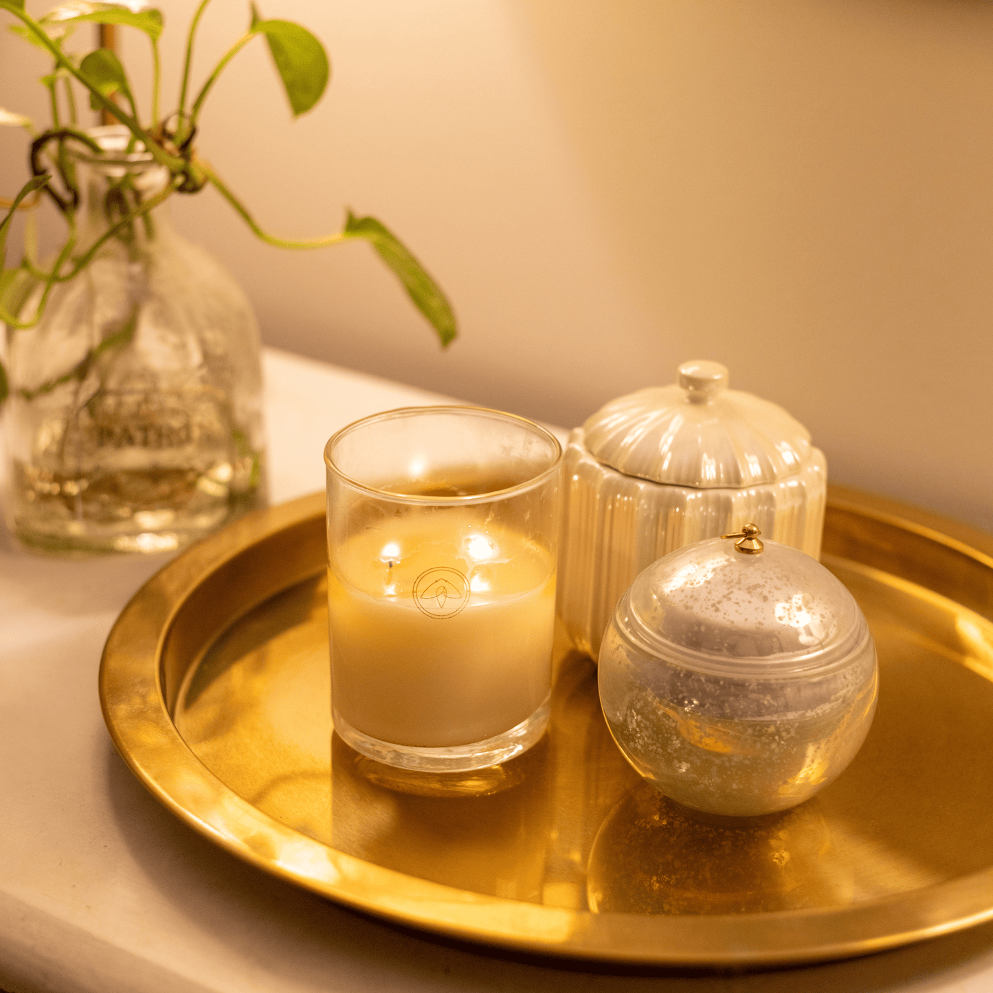 10oz clarity two wick candle on gold metal tray with home decor and planter in background