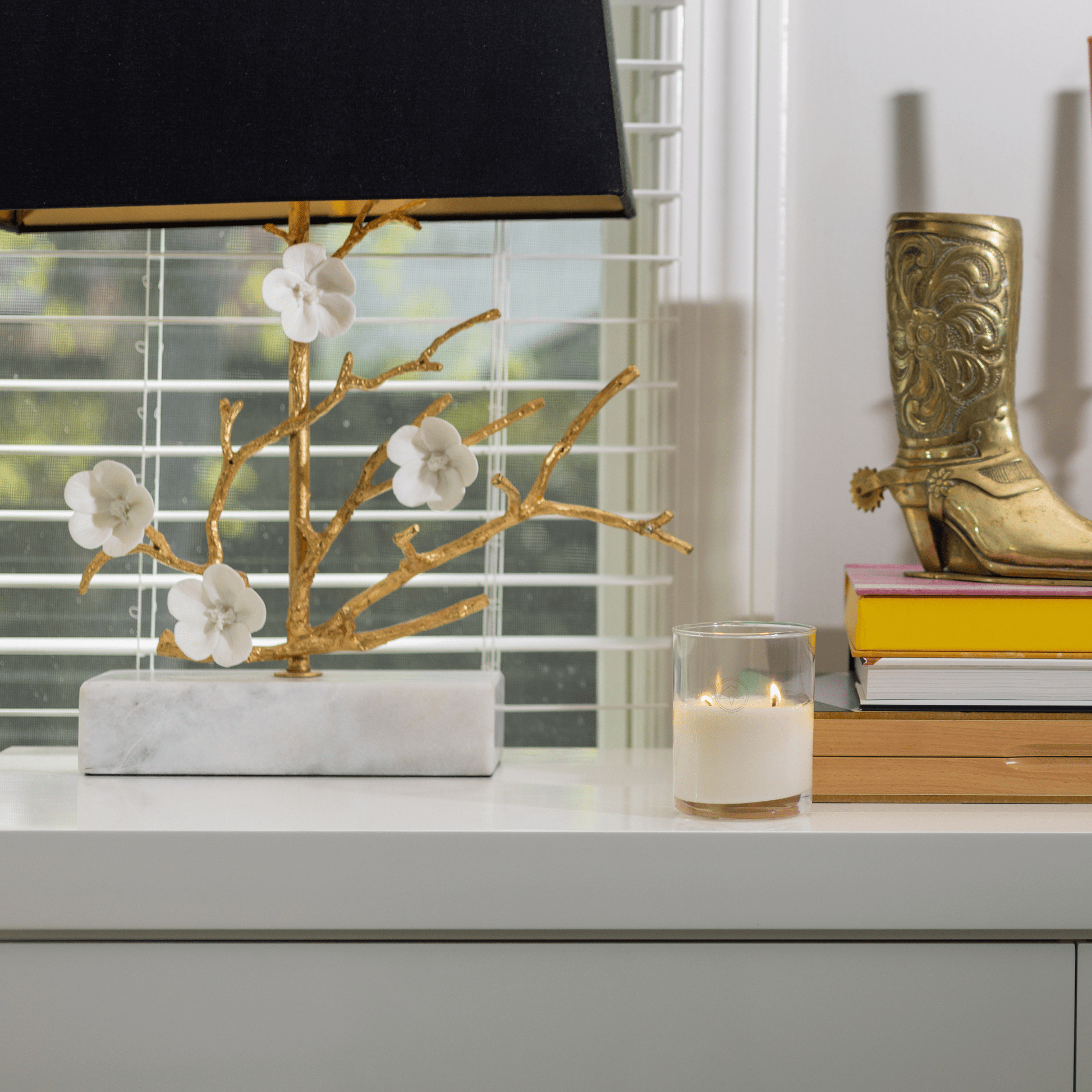 10oz Clarity two wick candle on a white table with books, home decor in front of a window