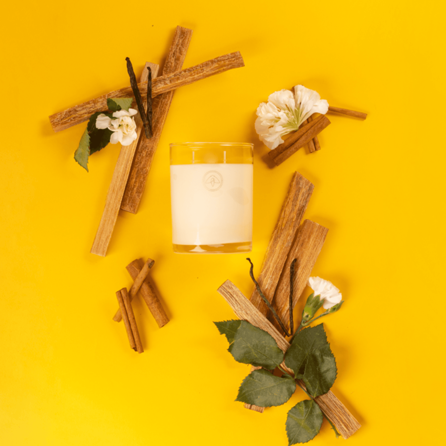 Clarity Shoreside Fire 10 candle on a yellow background surrounded by flowers, vanilla, and nutmeg