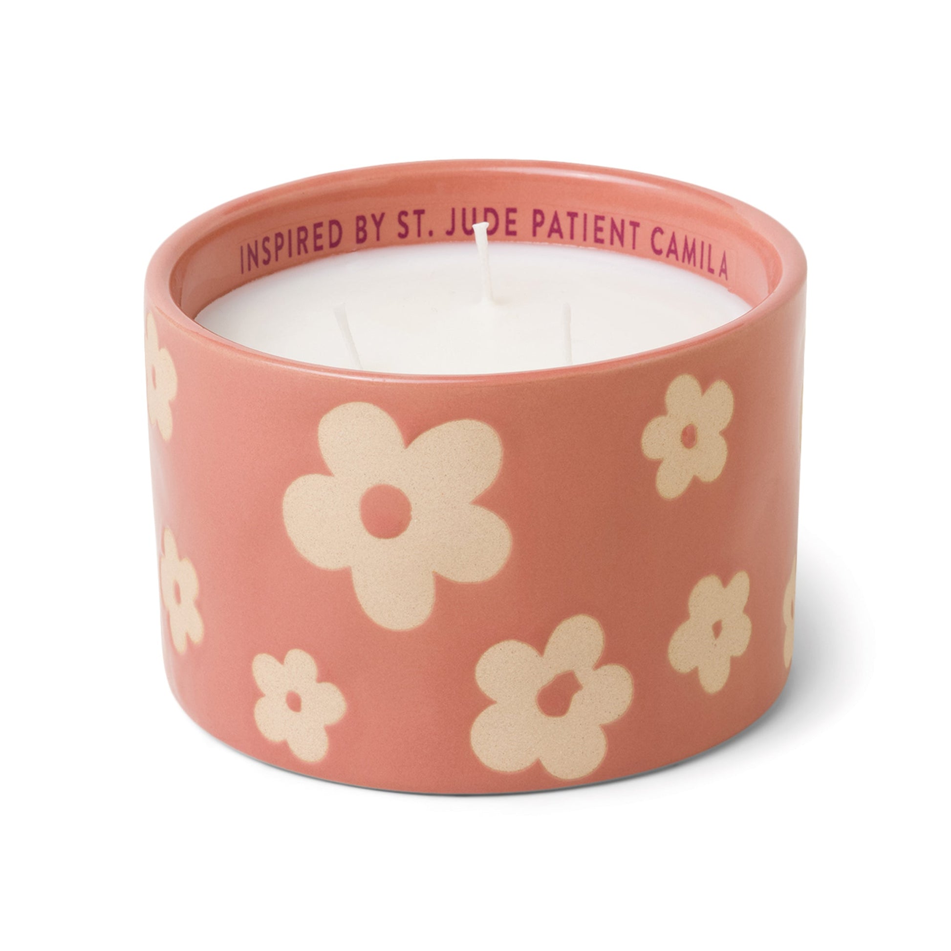 Pink ceramic candle with flowers and white soy wax center with three wicks. Debossed name on back side of the label with text "Inspired by St. Jude patient Yamila". Scented candle on white background