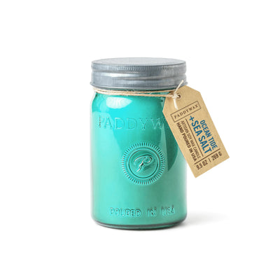 A turquoise Ocean Tide & Sea Salt - Relish 9.5 oz candle in an upcycled glass jar with a metal lid and brown tag.