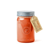 The Pumpkin + Spice - Relish 9.5 oz Candle features orange wax in a glass jar with a silver lid, brown Pumpkin Spice tag, embossed Paddywax logo, and stylish storage—part of the Relish collection.