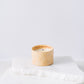 Yellow ceramic candle with rainbows and white soy wax center with three wicks burning 