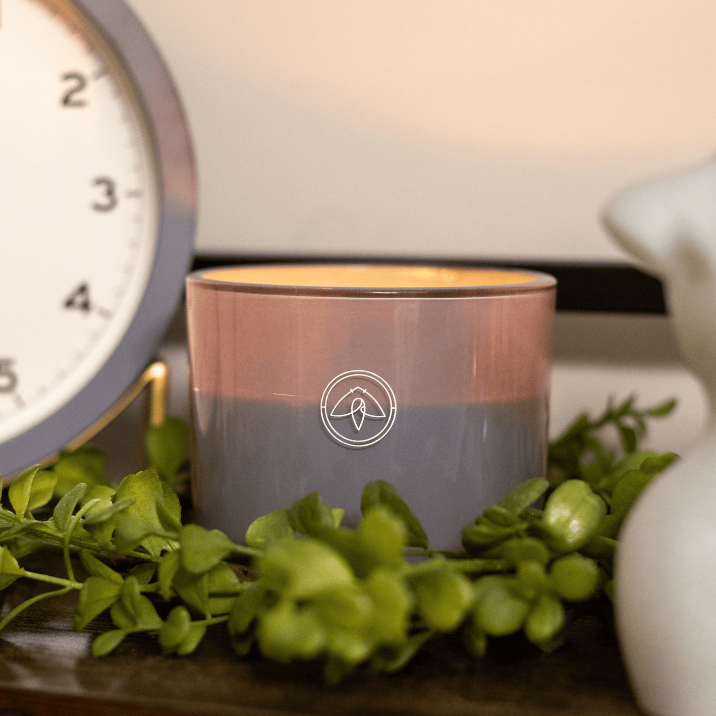 10oz Serenity two wick candle close up next to a clock and other home decor