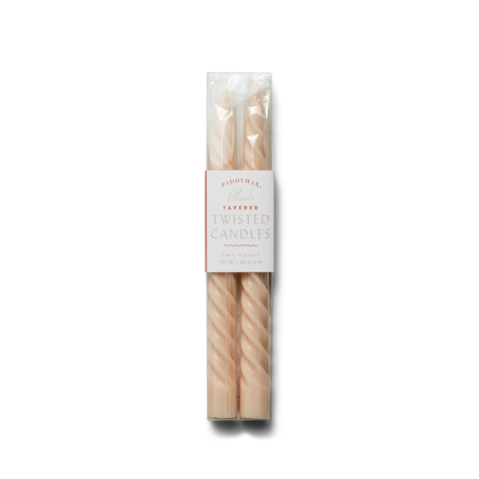 two blush-colored twisted taper candles; pictured inside clear packaging with white label