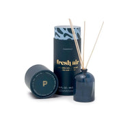 The Fresh Air - 1.5 oz Diffuser features a dark blue milky glass bottle with gold "fresh air" text, natural wooden reeds, and a matching cylindrical container—cap off to the side—making it a perfect giftable fragrance.