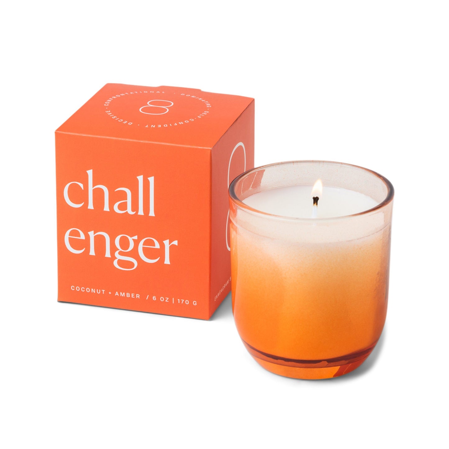 Candle with a vessel of clear glass that fades to orange at the bottom; pictured next to the orange box which reads “challenger”